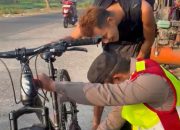 Kapolsek Telukjambe Barat bersama Anggota Bantu WNA Asal Jepang Perbaiki Sepeda dan Antar ke Bengkel  ‎